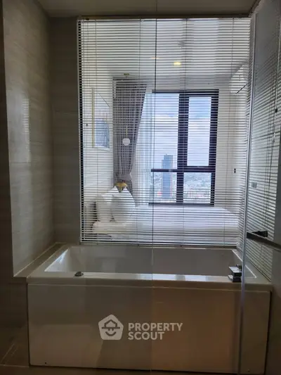 Modern bathroom with bathtub and city view through glass partition