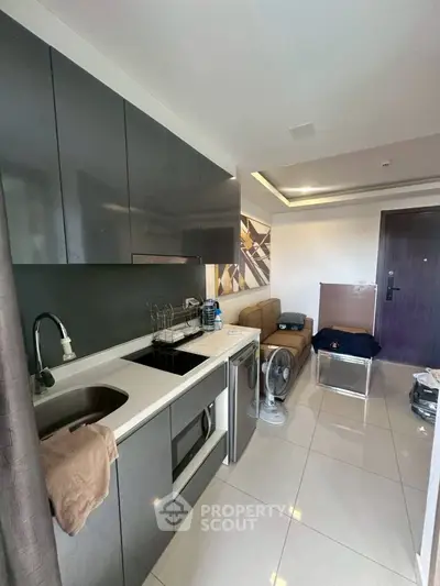Modern compact kitchen with sleek cabinets and integrated appliances in a stylish apartment.