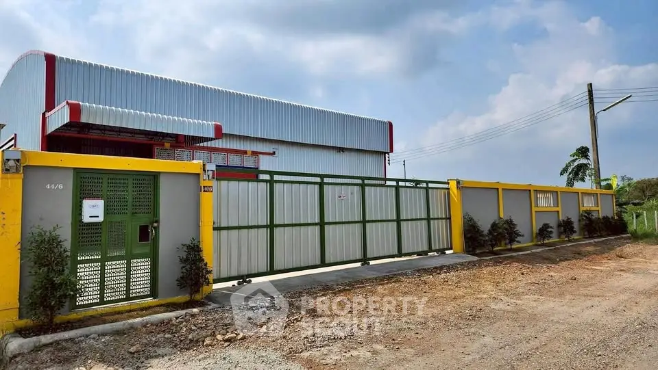 Modern industrial warehouse with secure gated entrance and spacious outdoor area.