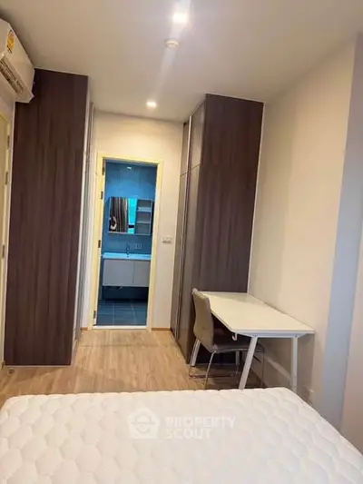Modern bedroom with study area and ensuite bathroom in a stylish apartment.