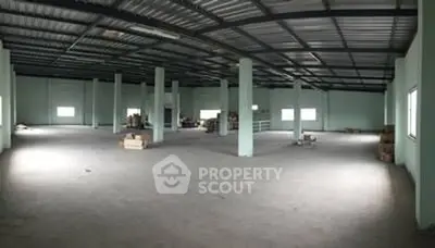 Spacious industrial warehouse with high ceilings and ample natural light.