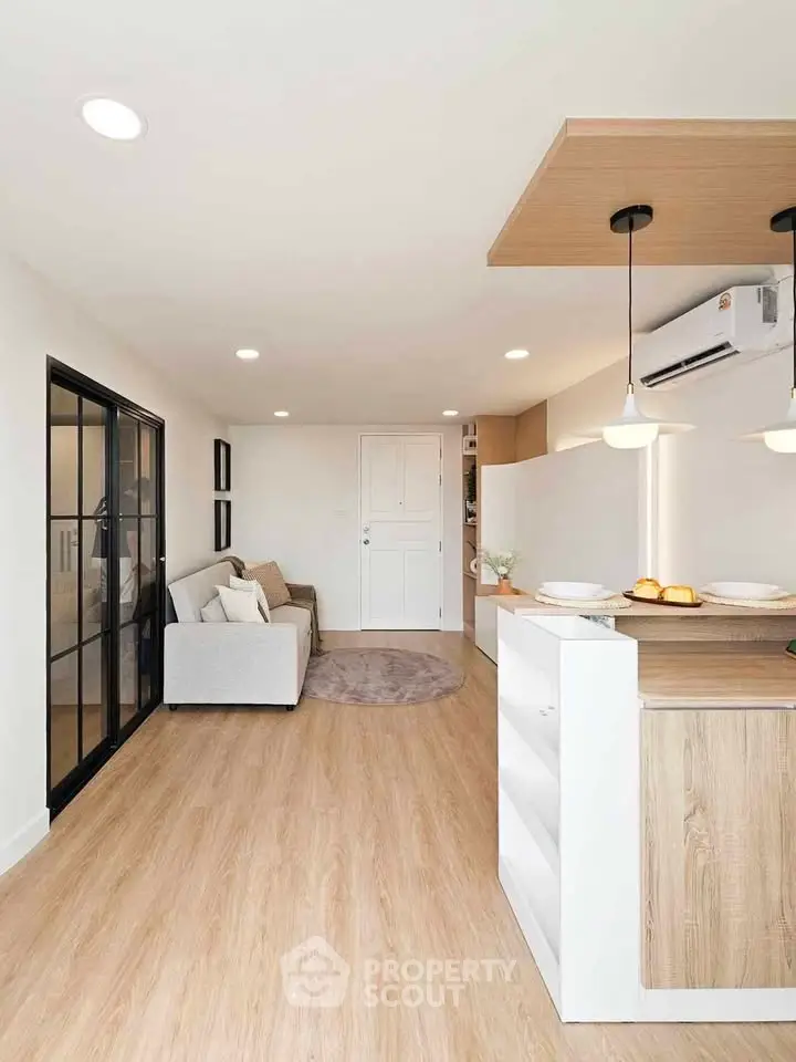 Modern open-layout living room with cozy sofa and stylish kitchen area