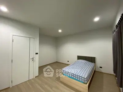 Spacious minimalist bedroom with modern lighting and wooden flooring