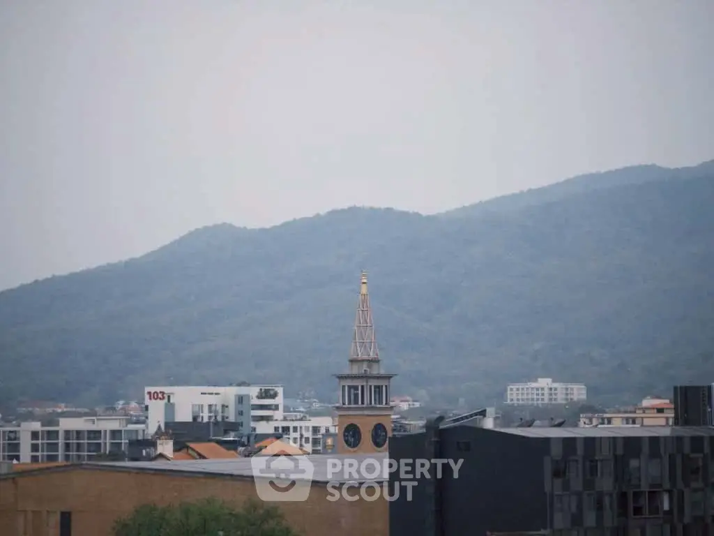 Scenic cityscape view with mountains and architectural buildings in the foreground.