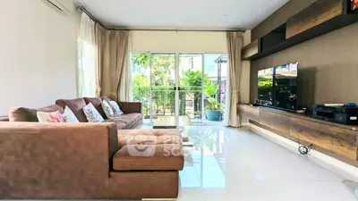 Spacious living room with modern decor and large windows overlooking garden.