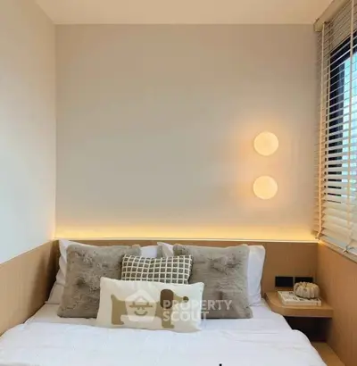 Cozy bedroom with modern lighting and plush pillows, perfect for relaxation.