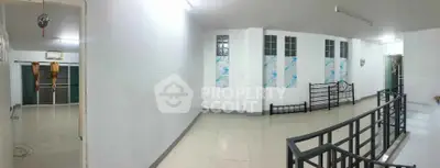 Spacious interior with modern railing and tiled flooring, ideal for versatile use.