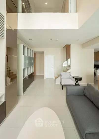 Modern living room with high ceiling and stylish furniture in a contemporary apartment.