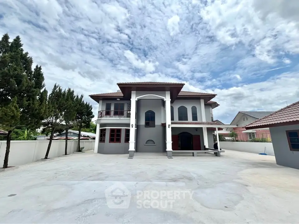 Stunning two-story house with spacious driveway and elegant architecture under a clear blue sky.