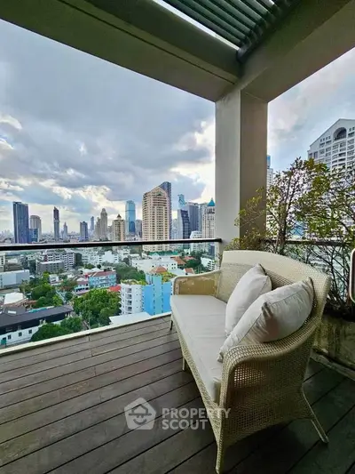 Stunning city view from a spacious balcony with cozy seating, perfect for relaxation and enjoying urban skyline.