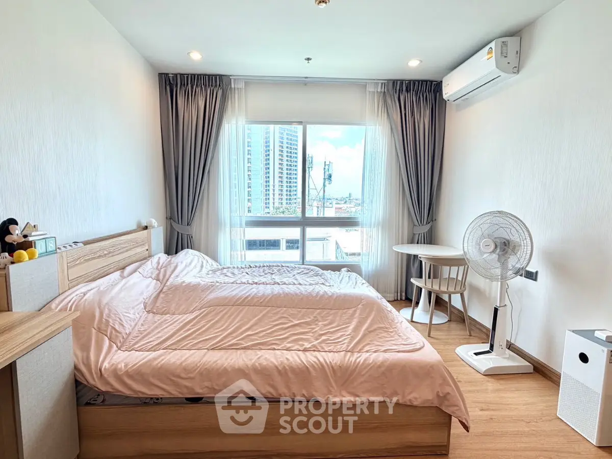 Modern bedroom with city view, featuring cozy bed and stylish decor.