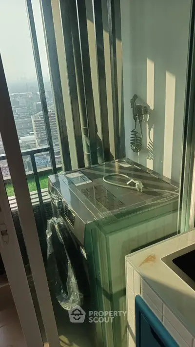 Modern apartment balcony with washing machine and city view, perfect for urban living.