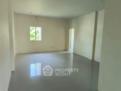 Spacious empty room with glossy tiled floor and large window, perfect for customization.