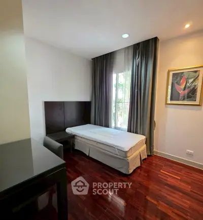Cozy bedroom with hardwood floors and natural light in modern apartment