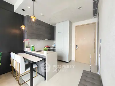 Modern kitchen with sleek design, featuring a breakfast bar and stylish lighting, perfect for contemporary living.