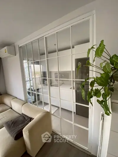 Modern living room with sliding glass doors leading to a sleek kitchen