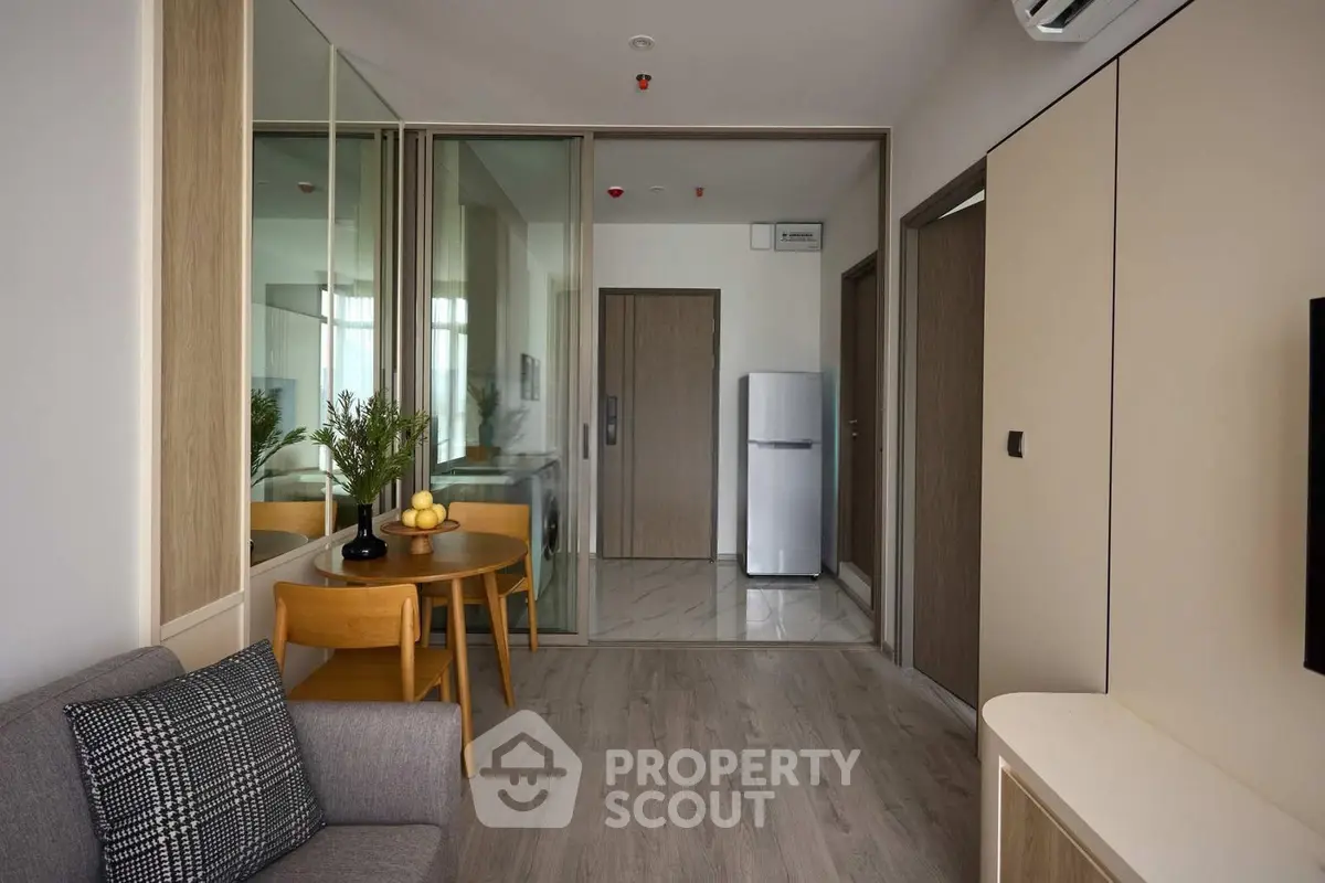 Modern apartment interior with sleek design and stylish furniture, featuring a cozy living area and compact kitchen.