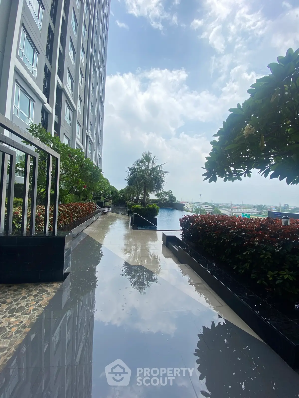 Luxurious high-rise building with stunning poolside view and lush greenery