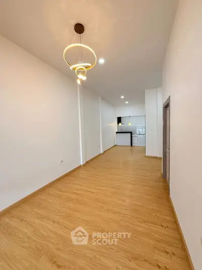 Spacious open-plan living area with modern kitchen and elegant lighting