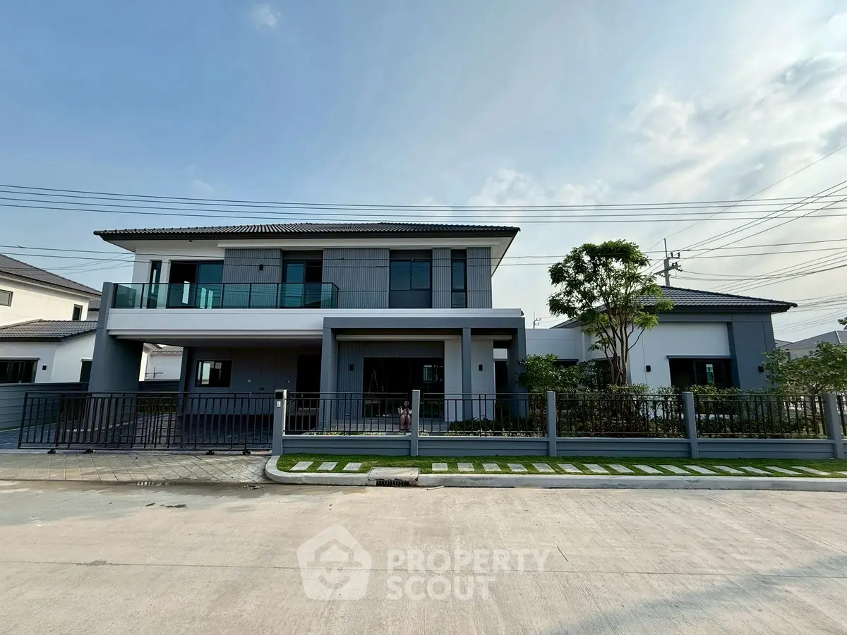 Modern two-story house with spacious balcony and landscaped front yard
