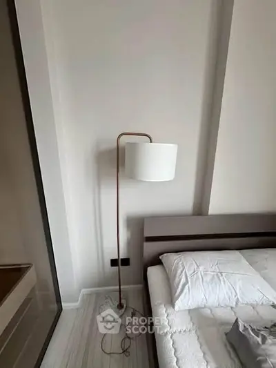 Modern bedroom with stylish floor lamp and minimalist decor