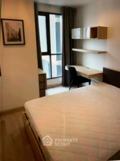 Modern bedroom with study desk and large window in urban apartment