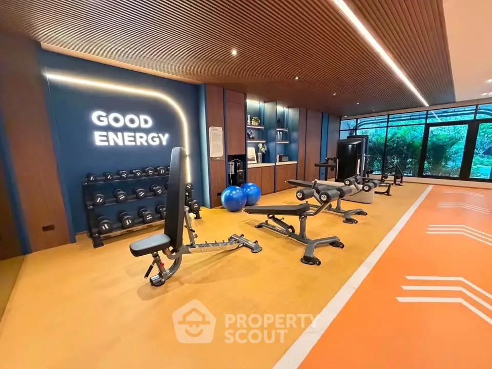Modern gym with state-of-the-art equipment and motivational decor in luxury residential building.