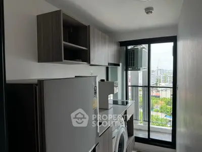 Modern kitchen with sleek appliances and city view from window.