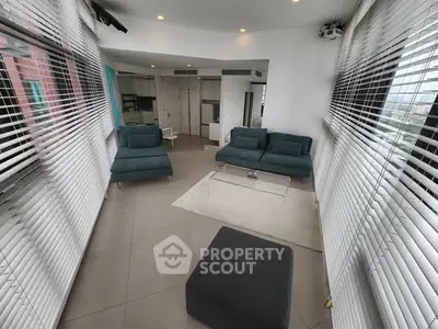 Spacious modern living room with panoramic windows and stylish furniture.