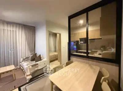 Modern apartment interior with open kitchen and cozy living area, featuring stylish furniture and warm lighting.