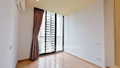 Bright empty room with large window and city view, perfect for customization.