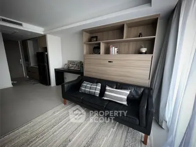 Modern living room with sleek black sofa and stylish shelving unit