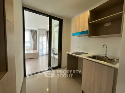 Modern compact kitchen with open layout and sleek design in a stylish apartment.