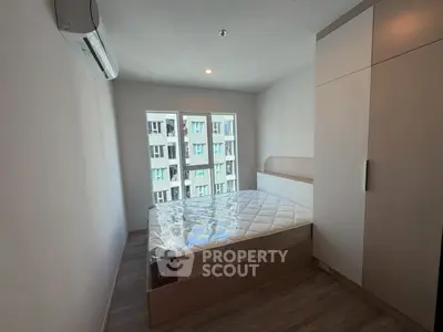 Modern bedroom with large windows and built-in wardrobe in urban apartment