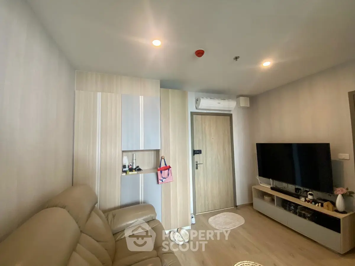 Modern living room with leather sofa, wall-mounted TV, and stylish storage cabinets.