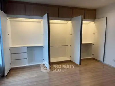 Spacious modern wardrobe with ample storage in a stylish bedroom setting.