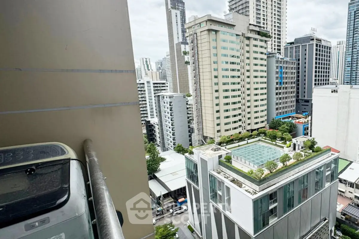 Stunning urban view from high-rise balcony overlooking cityscape and modern buildings.