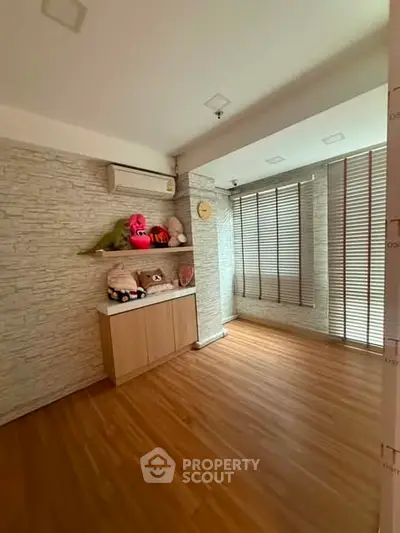 Spacious room with wooden flooring and modern decor, perfect for a cozy living space.