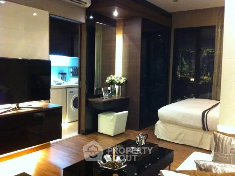 Luxurious modern studio apartment with sleek design and cozy ambiance, featuring a washing machine and elegant decor.