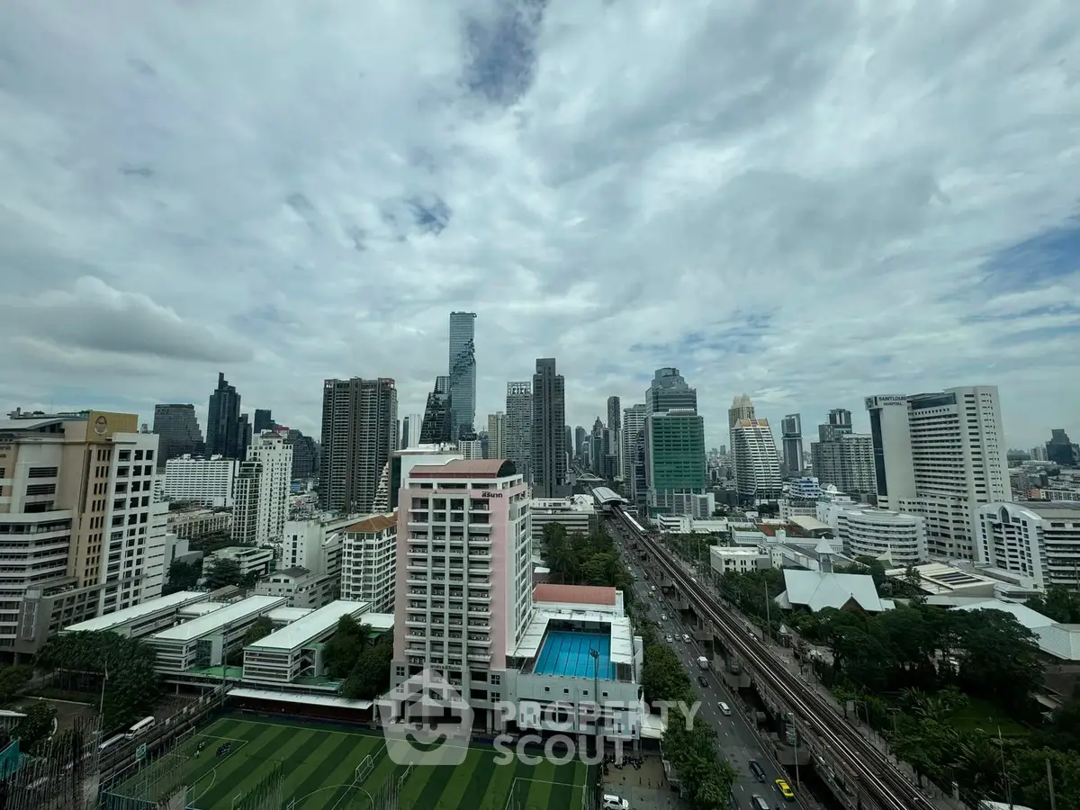 Stunning cityscape view showcasing modern skyscrapers and urban landscape under a dramatic cloudy sky.