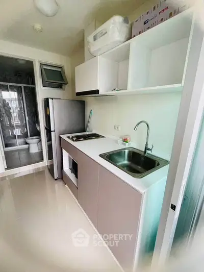 Modern compact kitchen with sleek cabinetry and stainless steel appliances