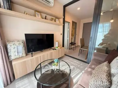 Modern living room with stylish decor and glass coffee table in cozy apartment.