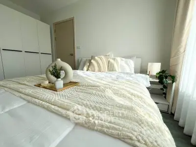 Cozy bedroom with plush bedding and modern decor in a bright, inviting space.