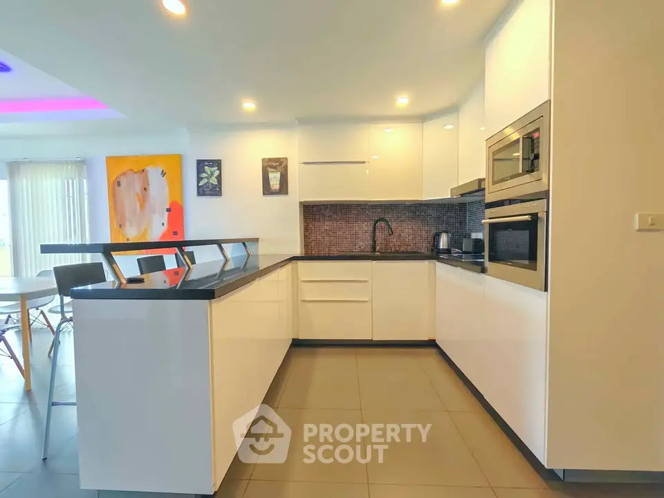 Modern kitchen with sleek white cabinets and built-in appliances in a stylish open layout.