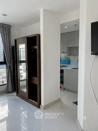 Modern apartment interior with sleek kitchen and stylish wardrobe, offering urban living with city views.