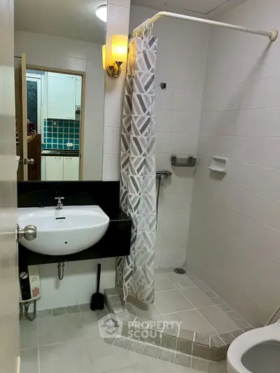 Modern bathroom with shower and stylish sink in a contemporary apartment.