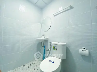 Modern minimalist bathroom with white tiles and round mirror