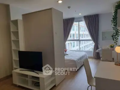 Modern studio apartment with natural light and stylish decor, featuring a cozy bedroom and living area.