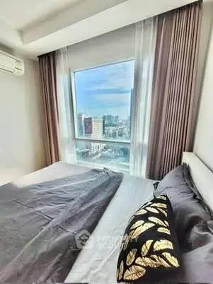 Modern bedroom with city view, featuring elegant curtains and stylish bedding.