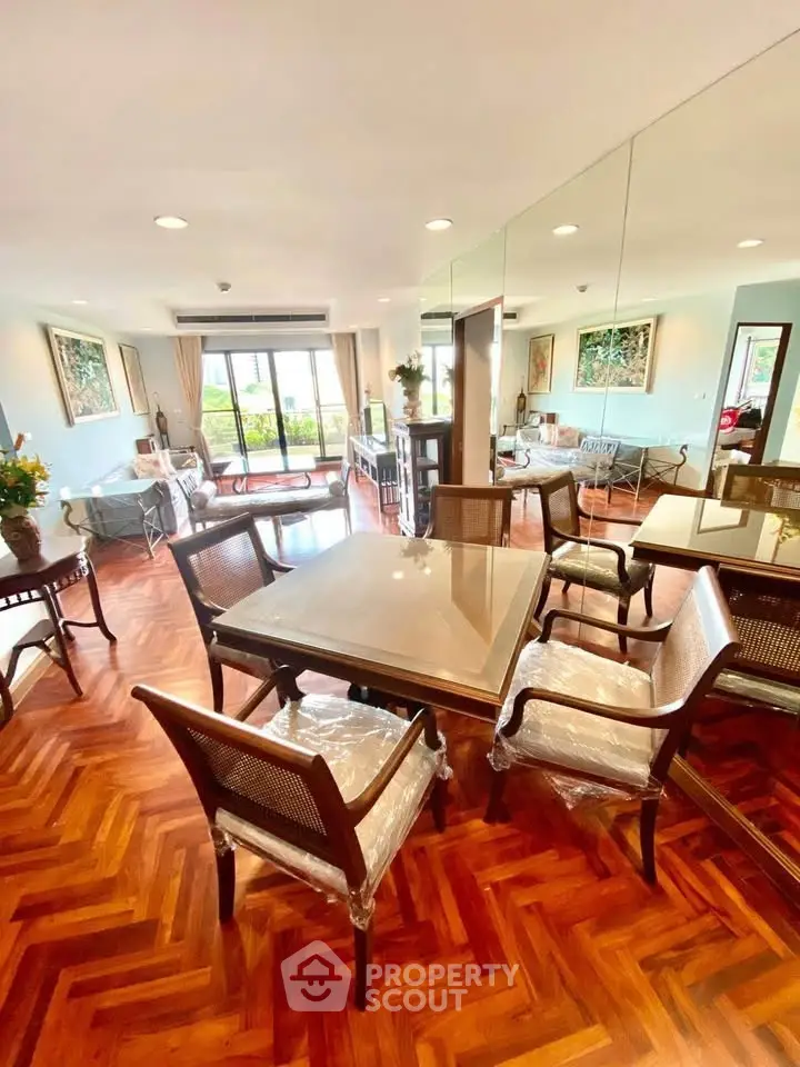 Elegant dining area with wooden flooring and stylish furniture in a spacious living room.